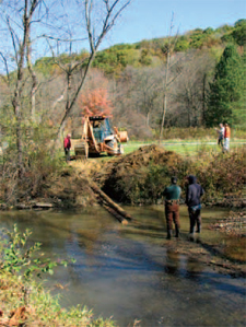 Watershed staff installs a multilog
vane deflector in Tubmill Creek,
used for erosion control and
creation of fish habitat.