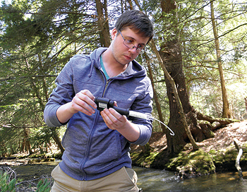 Alex Rudowski, an AmeriCorps watershed 
technician, assesses the water quality 
at a high-value conservation site. 